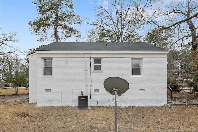 view of property exterior featuring crawl space, central AC, and brick siding