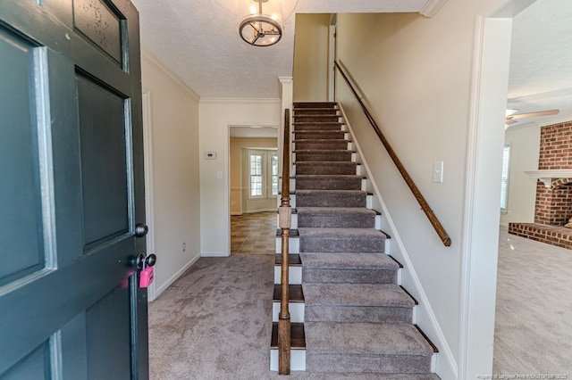 foyer featuring light carpet, stairway, a textured ceiling, and crown molding