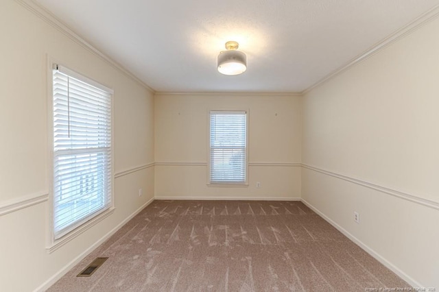 carpeted empty room featuring visible vents, baseboards, and ornamental molding