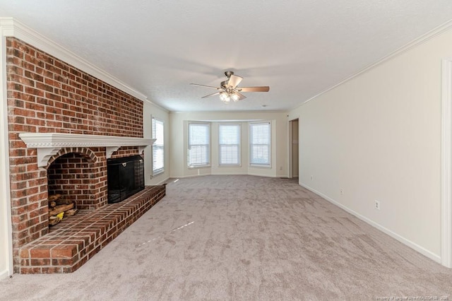 unfurnished living room with baseboards, carpet, ornamental molding, a fireplace, and a ceiling fan