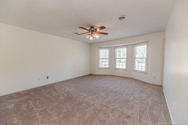 empty room with baseboards, carpet, visible vents, and ceiling fan