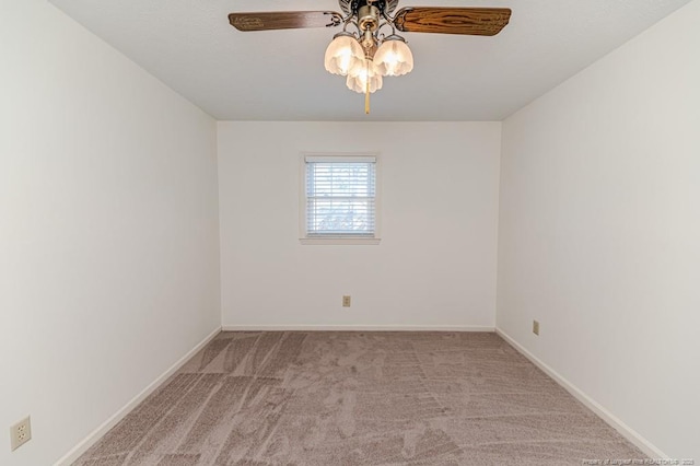 carpeted empty room featuring baseboards and a ceiling fan