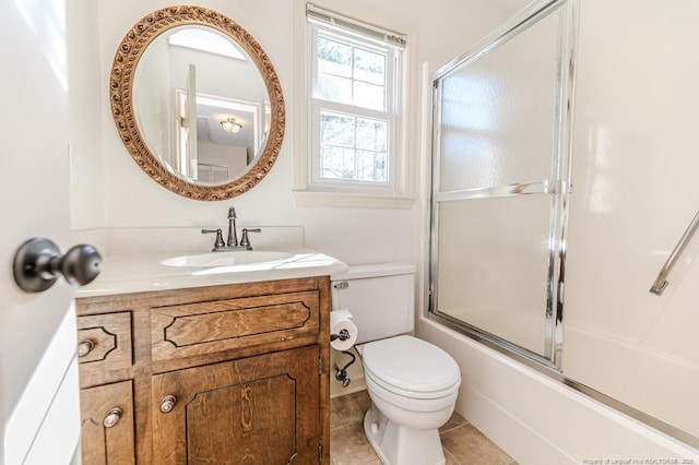 full bathroom featuring enclosed tub / shower combo, toilet, vanity, and tile patterned flooring