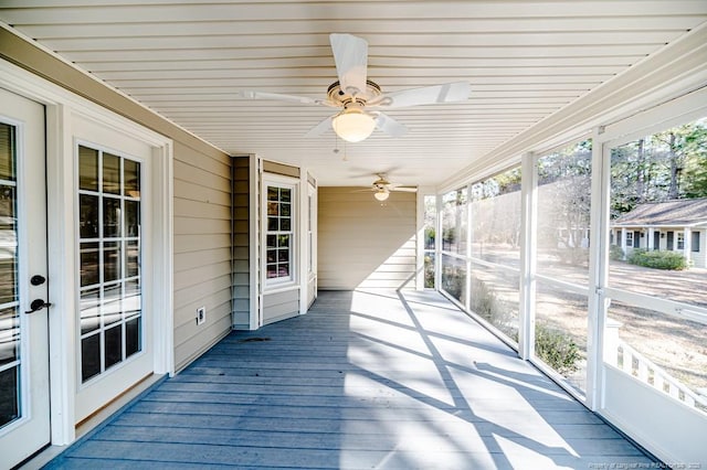 unfurnished sunroom with ceiling fan