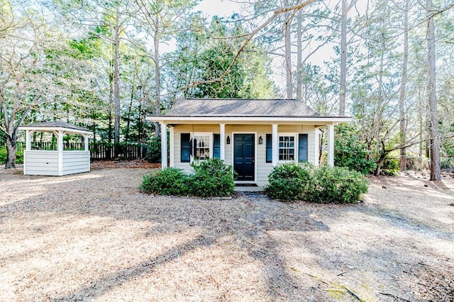 view of front of home featuring roof with shingles and fence