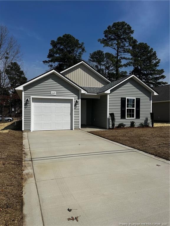 single story home with a garage, board and batten siding, and concrete driveway