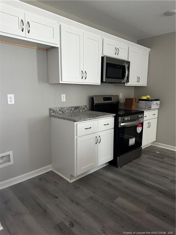 kitchen featuring baseboards, appliances with stainless steel finishes, dark wood finished floors, and white cabinetry