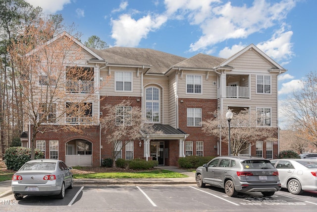 view of front facade with brick siding and uncovered parking