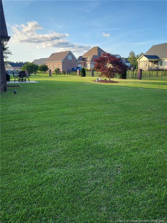 view of yard featuring fence and a residential view