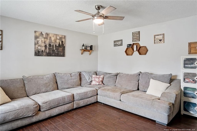 living room featuring dark wood-type flooring, a ceiling fan, and a textured ceiling