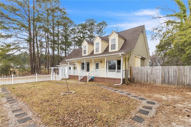 cape cod home featuring covered porch, roof with shingles, and fence