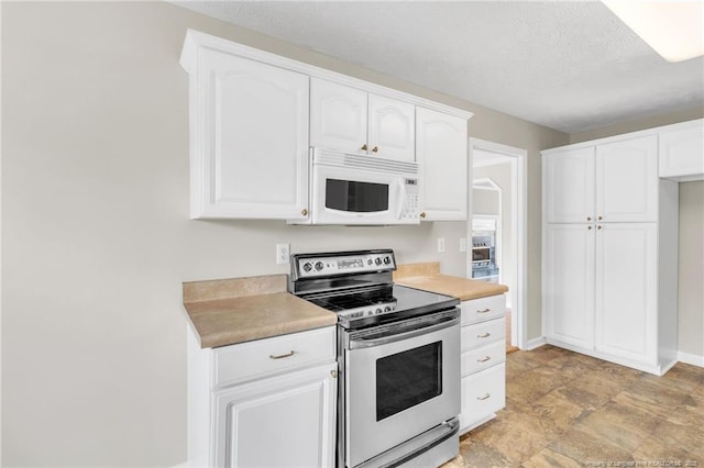 kitchen featuring a textured ceiling, white cabinetry, light countertops, stainless steel electric range oven, and white microwave