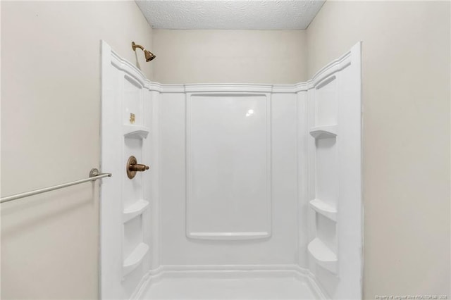 full bathroom with walk in shower and a textured ceiling