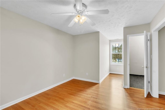 unfurnished bedroom with light wood-type flooring, baseboards, a textured ceiling, and ceiling fan