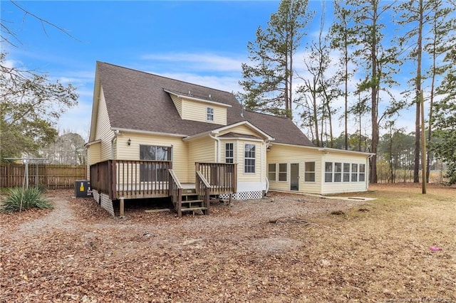 rear view of house featuring fence, a sunroom, central AC, a shingled roof, and a deck