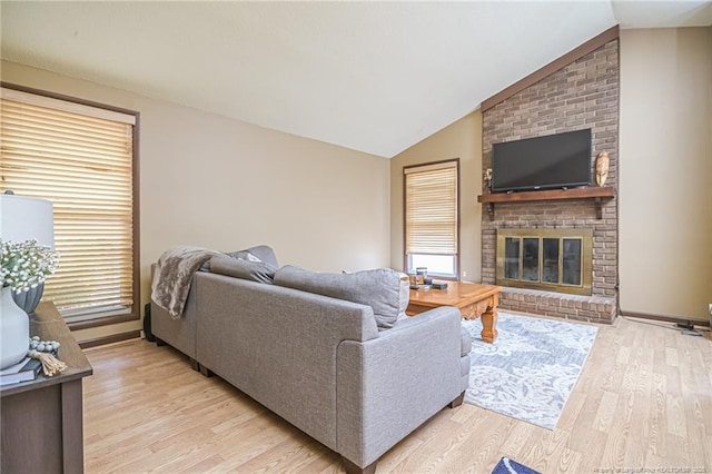 living room with a brick fireplace, baseboards, light wood-style floors, and vaulted ceiling