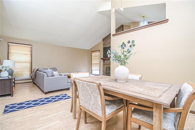 dining area with vaulted ceiling and light wood finished floors