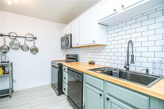 kitchen with a sink, stainless steel appliances, wooden counters, and backsplash