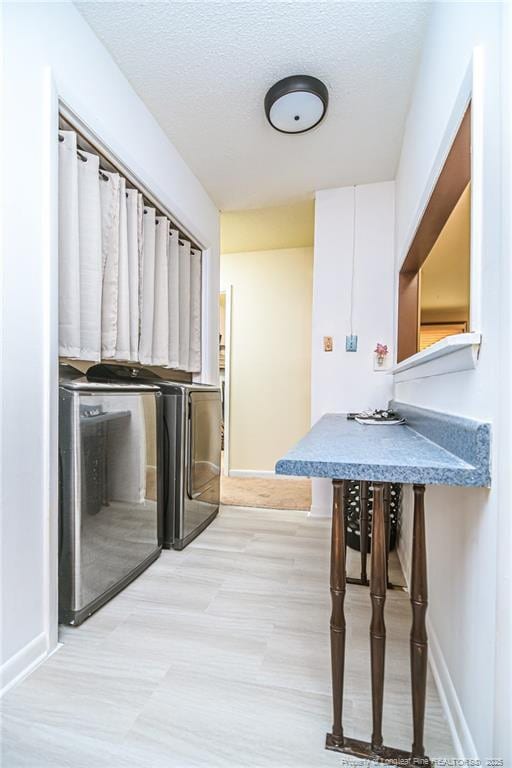 kitchen with light wood-style floors, baseboards, and a textured ceiling