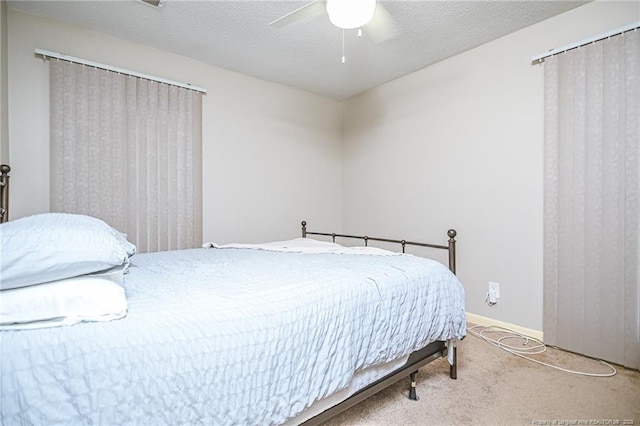 bedroom with baseboards, a textured ceiling, carpet, and a ceiling fan