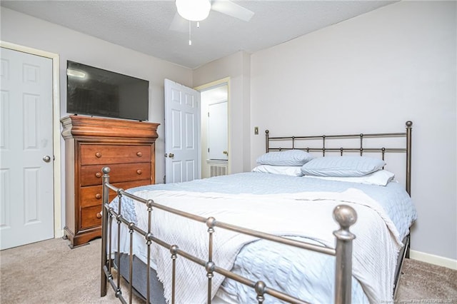 carpeted bedroom featuring ceiling fan, baseboards, and a textured ceiling