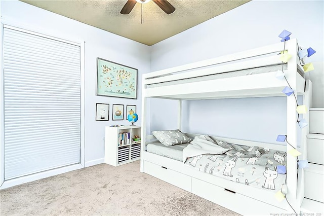 bedroom featuring a ceiling fan, carpet floors, and a textured ceiling