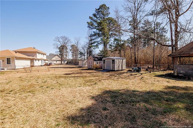 view of yard featuring an outbuilding, a storage shed, and a fenced backyard