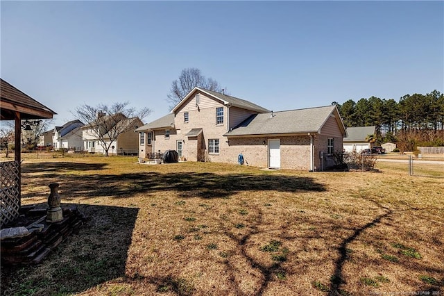 back of property featuring a lawn and fence