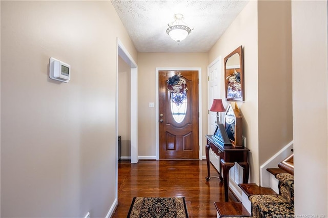 entrance foyer featuring dark wood finished floors, stairs, baseboards, and a textured ceiling