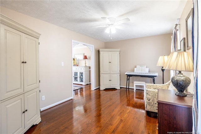 office with baseboards, a textured ceiling, a ceiling fan, and wood finished floors