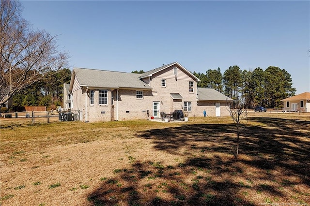 rear view of house with central air condition unit, fence, a lawn, and a patio area