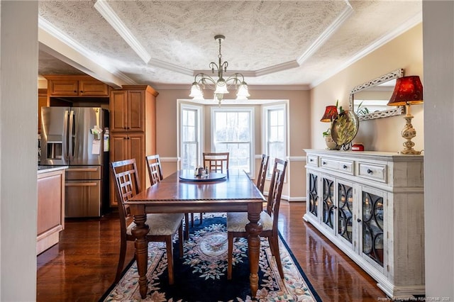 dining area with a tray ceiling, a notable chandelier, dark wood-style flooring, and crown molding