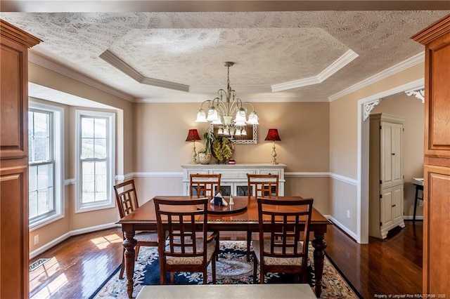 dining room with a textured ceiling, a raised ceiling, dark wood-style floors, and a chandelier