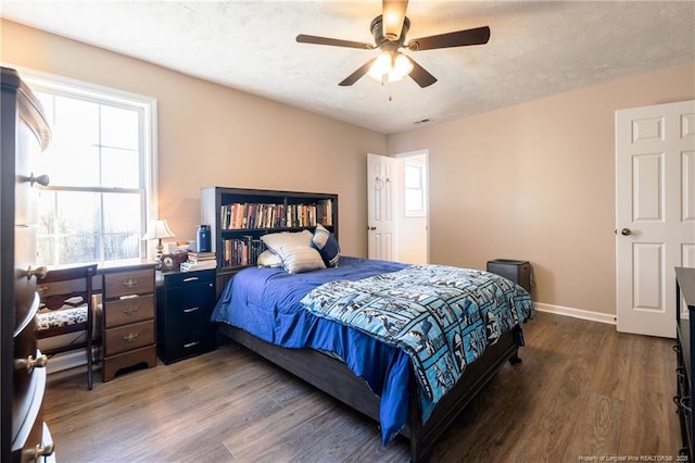 bedroom featuring ceiling fan, wood finished floors, baseboards, and a textured ceiling