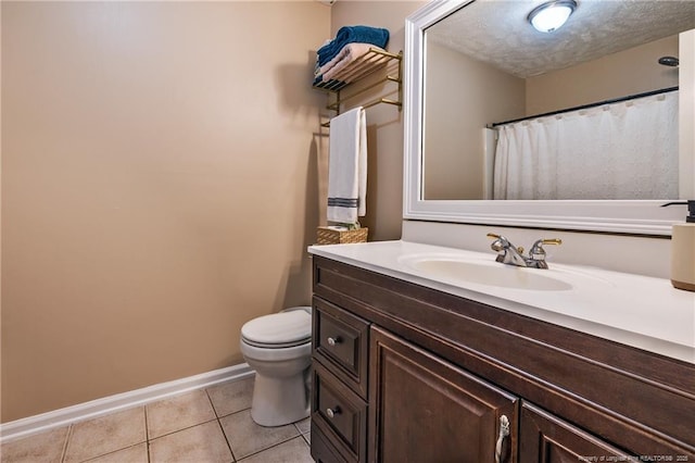 bathroom featuring vanity, baseboards, a textured ceiling, tile patterned floors, and toilet