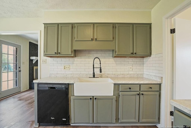 kitchen with a sink, dishwasher, light countertops, a textured ceiling, and green cabinetry