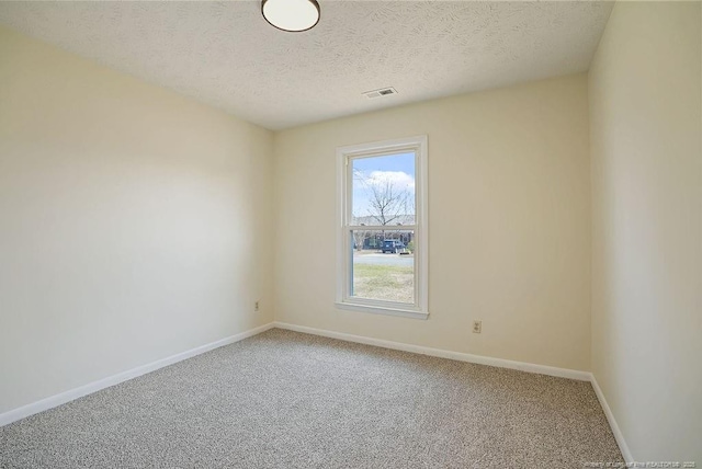 empty room with visible vents, baseboards, carpet, and a textured ceiling