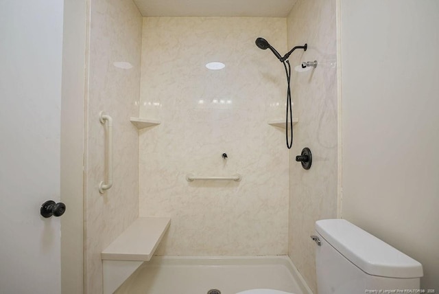 bathroom featuring toilet and a tile shower