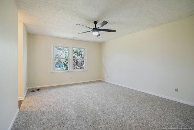 carpeted spare room featuring a textured ceiling, baseboards, and a ceiling fan