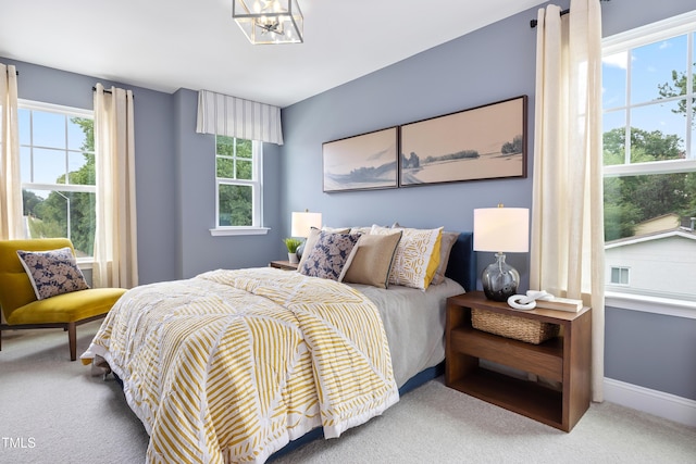 bedroom featuring a notable chandelier, baseboards, and carpet floors