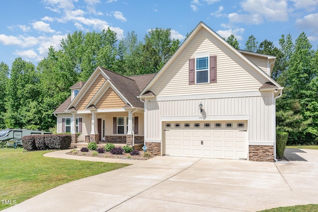 craftsman inspired home with a porch, driveway, a front yard, an attached garage, and stone siding