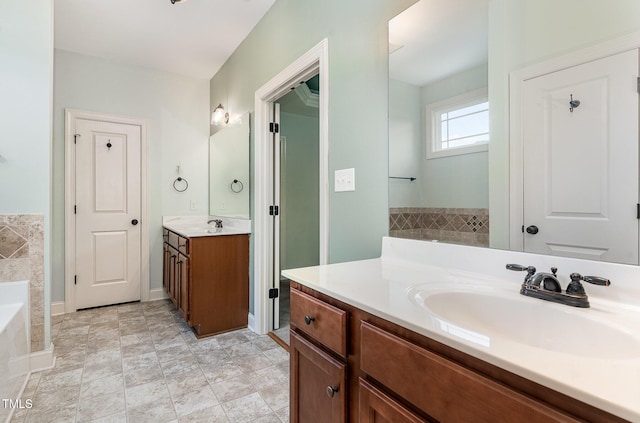 full bath featuring a garden tub, a sink, and two vanities