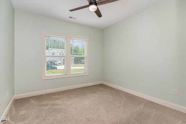 carpeted spare room with baseboards, ceiling fan, and visible vents