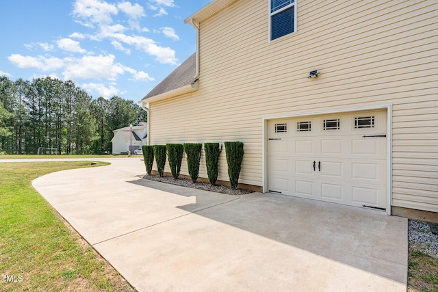 view of property exterior with a lawn, a garage, roof with shingles, and driveway