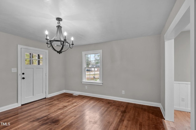 interior space with baseboards, an inviting chandelier, and wood finished floors