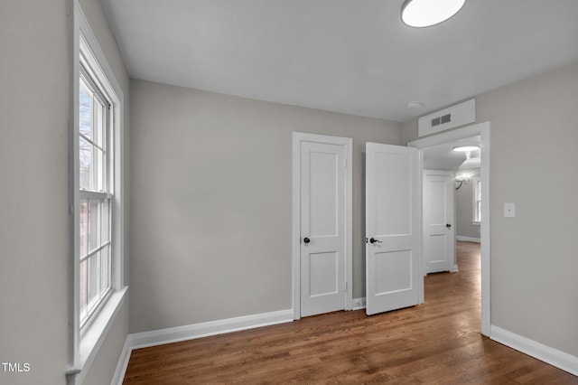 unfurnished bedroom featuring wood finished floors and baseboards