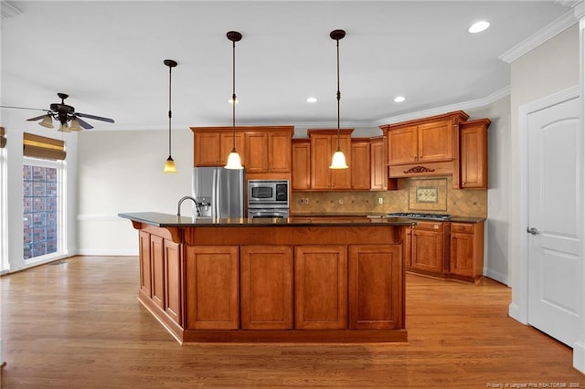 kitchen featuring a ceiling fan, brown cabinetry, appliances with stainless steel finishes, dark countertops, and backsplash