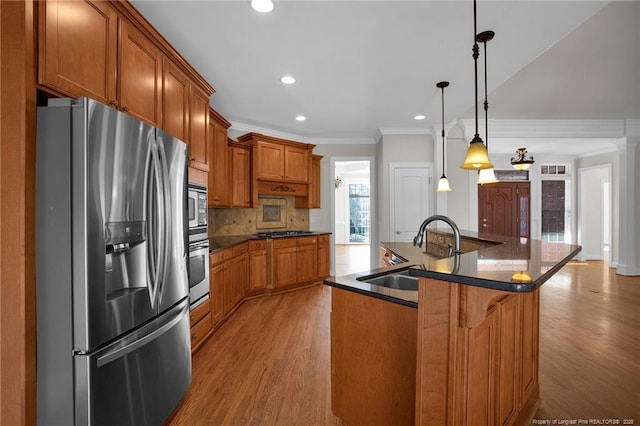 kitchen with a sink, stainless steel appliances, brown cabinets, and dark countertops