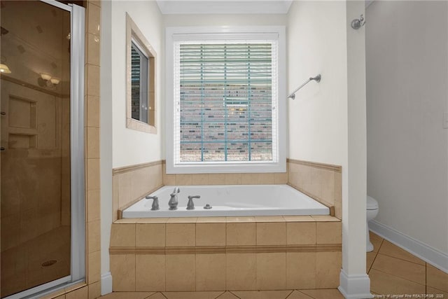 bathroom with tile patterned floors, a shower stall, toilet, and a garden tub