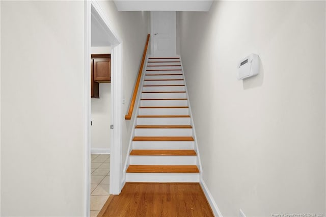 staircase with wood finished floors and baseboards